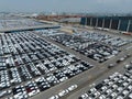 Aerial view of new cars stock at factory parking lot. Above view cars parked in a row. Automotive industry. Logistics business. Royalty Free Stock Photo