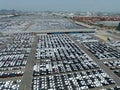 Aerial view of new cars stock at factory parking lot. Above view cars parked in a row. Automotive industry. Logistics business. Royalty Free Stock Photo