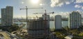 Aerial view of new developing residense in american urban area. Tower cranes at industrial construction site in Miami