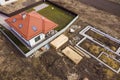 Aerial view of new house roof with attic windows and building site, foundation of future house, stacks of bricks and building Royalty Free Stock Photo