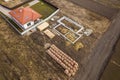 Aerial view of new house roof with attic windows and building site, foundation of future house, stacks of bricks and building Royalty Free Stock Photo