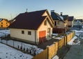 Aerial view of new residential house cottage and attached garage with shingle roof on fenced yard on sunny winter day in modern Royalty Free Stock Photo
