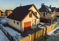 Aerial view of new residential house cottage and attached garage with shingle roof on fenced yard on sunny winter day in modern Royalty Free Stock Photo