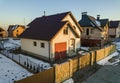 Aerial view of new residential house cottage and attached garage with shingle roof on fenced yard on sunny winter day in modern Royalty Free Stock Photo