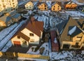 Aerial view of new residential house cottage and attached garage with shingle roof on fenced yard on sunny winter day in modern