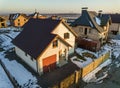 Aerial view of new residential house cottage and attached garage with shingle roof on fenced yard on sunny winter day in modern Royalty Free Stock Photo