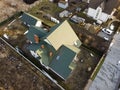 Aerial view of new residential house cottage and garage or barn with shingle roof on fenced yard on sunny day