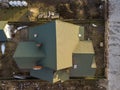 Aerial view of new residential house cottage and garage or barn with shingle roof on fenced yard on sunny day