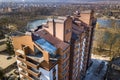 Aerial view of new tall apartment building in quiet area on background of developing city landscape under bright blue sky Royalty Free Stock Photo