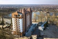 Aerial view of new tall apartment building in quiet area on background of developing city landscape under bright blue sky Royalty Free Stock Photo