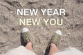 Aerial view of New year New you word on sand with people foot wear canvas shoe standing.goal resolutions for life Royalty Free Stock Photo