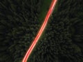 Aerial view of night green forest,  road and cars passing by. Royalty Free Stock Photo