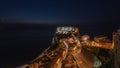 Aerial view of the night of houses and Castle Ruffo by the sea in Sicily, Italy