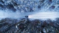 Aerial view of night winter road and car in forest. Drone shot. Royalty Free Stock Photo