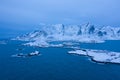 Aerial view of Norwegian fishing village in Reine City, Lofoten islands, Nordland, Norway, Europe. White snowy mountain hills, Royalty Free Stock Photo