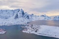 Aerial view of Norwegian fishing village in Reine City, Lofoten islands, Nordland, Norway, Europe. White snowy mountain hills, Royalty Free Stock Photo