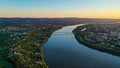 Aerial view of Novi Sad cityscape with river and Liberty bridge at sunset