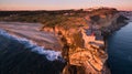 Aerial view of ocean and Nazare lighthouse at sunset, Portugal