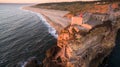 Aerial view of ocean, north Beach and Nazare lighthouse at sunset, Portugal