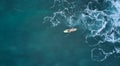 Aerial view of the ocean and surfer girl.