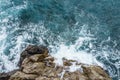 Aerial view of ocean wave crashing on rocky cliff with white spray and foam on deep blue sea water after storm Royalty Free Stock Photo