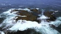 Aerial view of ocean waves crashing into rocks. Clip. Flying above turquoise water and giant boulders. Royalty Free Stock Photo