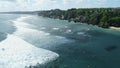 Aerial view of ocean with waves, surfers on Impossibles beach in Bali