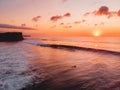 Aerial view of ocean with waves, surfers and warm sunset in Bali Royalty Free Stock Photo