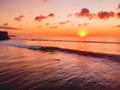 Aerial view of ocean with waves, surfers and warm sunset. Drone shot in Bali Royalty Free Stock Photo