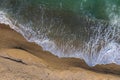 Aerial view of ocean waves washing a sandy shoreline