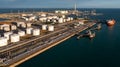 Aerial view oil tanker and oil storage tank terminal port at sunset