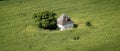 Aerial view of an old Farmhouse in the middle of a green field.