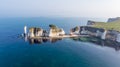 An aerial view of the Old Harry Rocks along the Jurassic coast with crystal clear water and white cliffs under a hazy sky