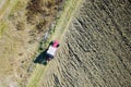 Aerial view of red Tractor harrowing soil