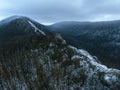 Aerial view of old ruins of fortress in the middle of winter forest. Drone view of snowy landscape with broken stone