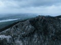 Aerial view of old ruins of fortress in the middle of winter forest. Drone view of snowy landscape with broken stone