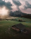 Aerial view of an old rural wooden house in the green field at bright sunset Royalty Free Stock Photo