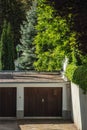 Aerial view of old wooden garage door with tall green trees Royalty Free Stock Photo