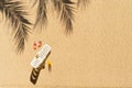 Aerial view of one sunbed, lounge, flip flops, orange juice, shadow of a palm tree on sand beach. Copy space. Summer and travel Royalty Free Stock Photo