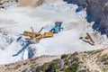 Aerial view of opencast mining quarry with one machinery on the blue sea background. Royalty Free Stock Photo