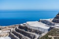 Aerial view of opencast mining quarry with one machinery on the blue sea background. Royalty Free Stock Photo