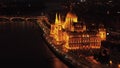 Aerial view of Orszaghaz on Danube river waterfront. Night shot of illuminated historic neogothic building. Budapest