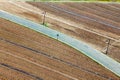 Aerial view over agriculture preparing vegetable fields with road throught