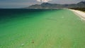 Aerial view over beautiful beach with crsytal clear pristine water on summer day.