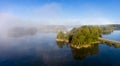 Aerial view over calm lake in morning mist