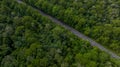 Aerial view over forest road with asphalt road and forest, Road in the middle of the forest up to mountain, Countryside road