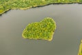 Aerial view over an island. The island is formed as a green heart. Royalty Free Stock Photo
