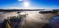 Aerial view over misty fields and lake in morning