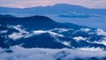 Aerial view over the mountains with sea of fog during morning sunrise in blue sky. Sea of clouds around mountain peaks at sunrise Royalty Free Stock Photo