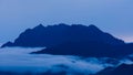 Aerial view over the mountains with sea of fog during morning sunrise in blue sky. Sea of clouds around mountain peaks at sunrise Royalty Free Stock Photo